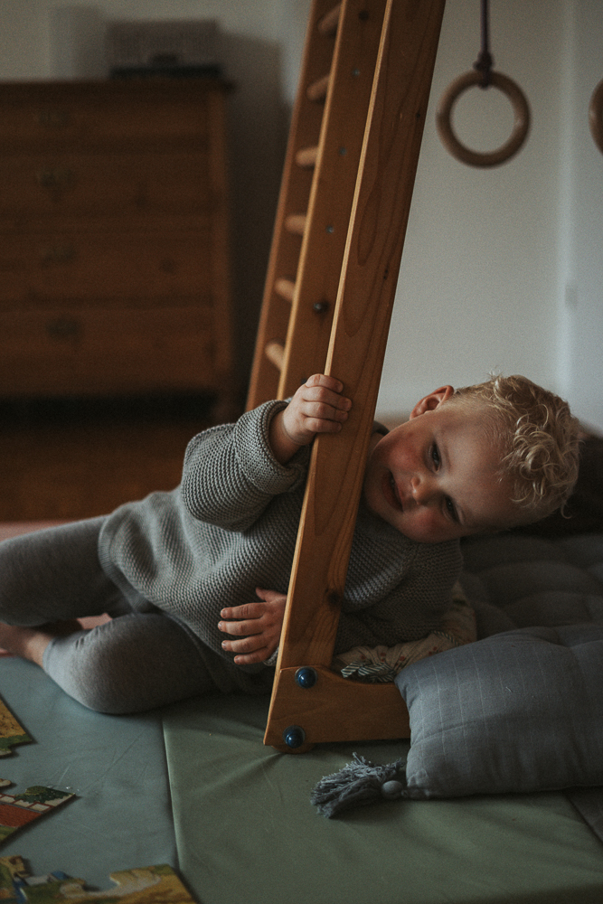 Junge macht Spaß an Leiter bei Familien Homestory fotografiert