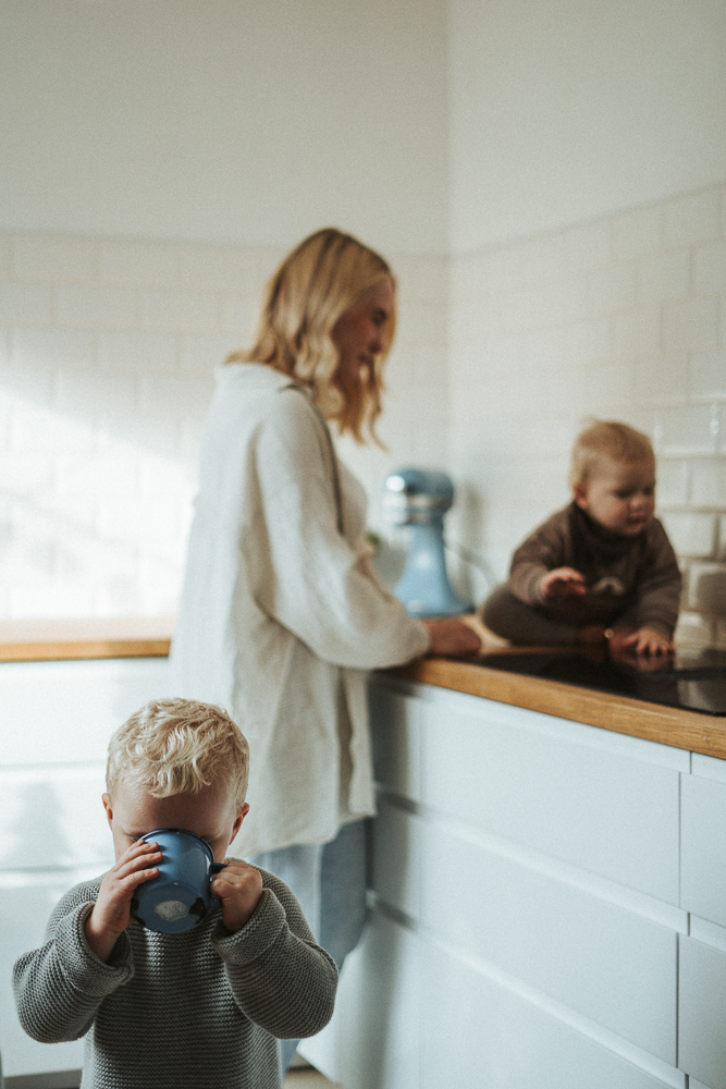 Kind trinkt aus einem Becher Mama mit Baby in Küche Familienshooting Homestory