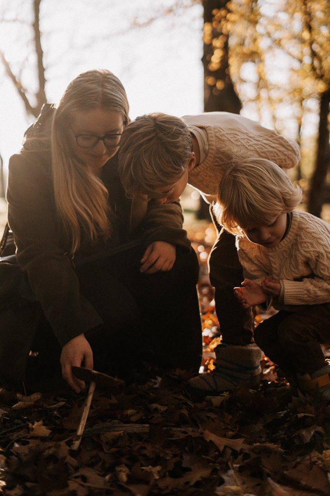 Mama und Kinder betrachten die Erde bei einem Fotoshootings im Herbst