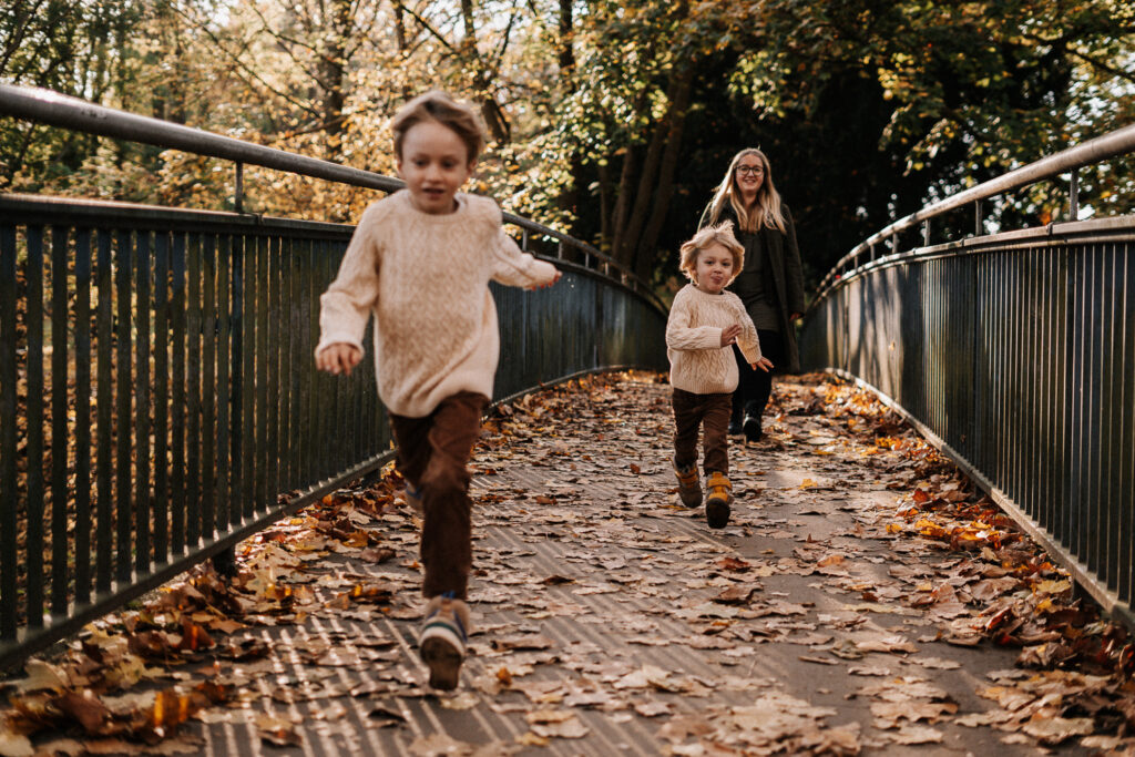 Zwei Jungen rennen über eine Brücke fotografiert bei Herbst Outdoorshooting