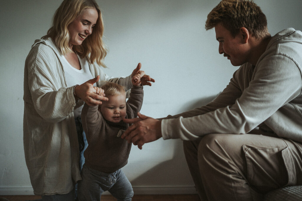 Mama und Papa Baby lernt laufen bei Familien Homestory