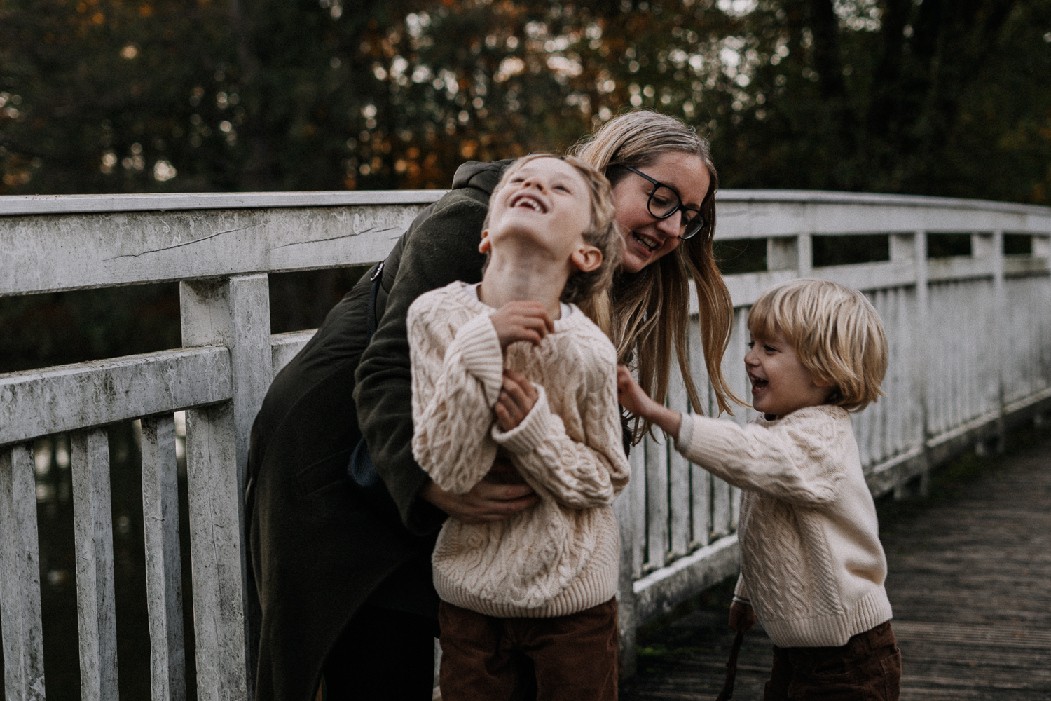 Familie Mutter und Söhne haben Spaß auf einer Brücke fotografiert bei Familienshooting
