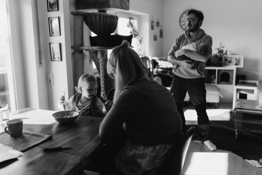 Familie beim Essen Vater mit Baby auf dem Arm