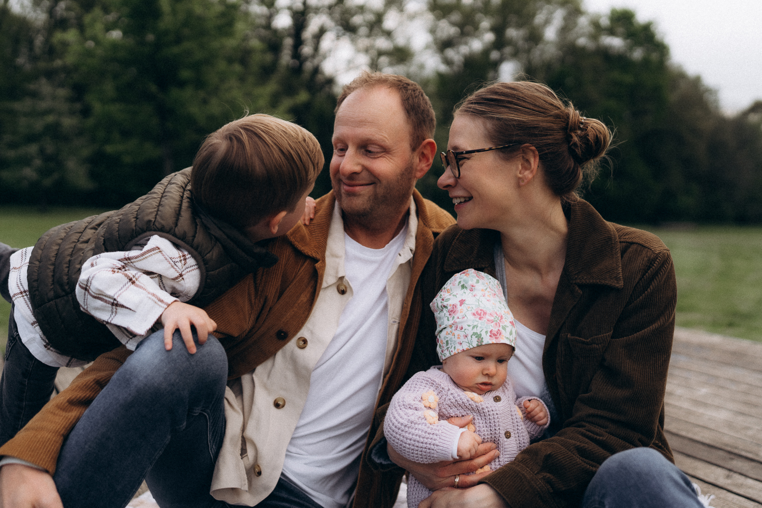 Familie Mutter Vater Sohn Tochter Baby bei einem Fotoshooting im Grünen