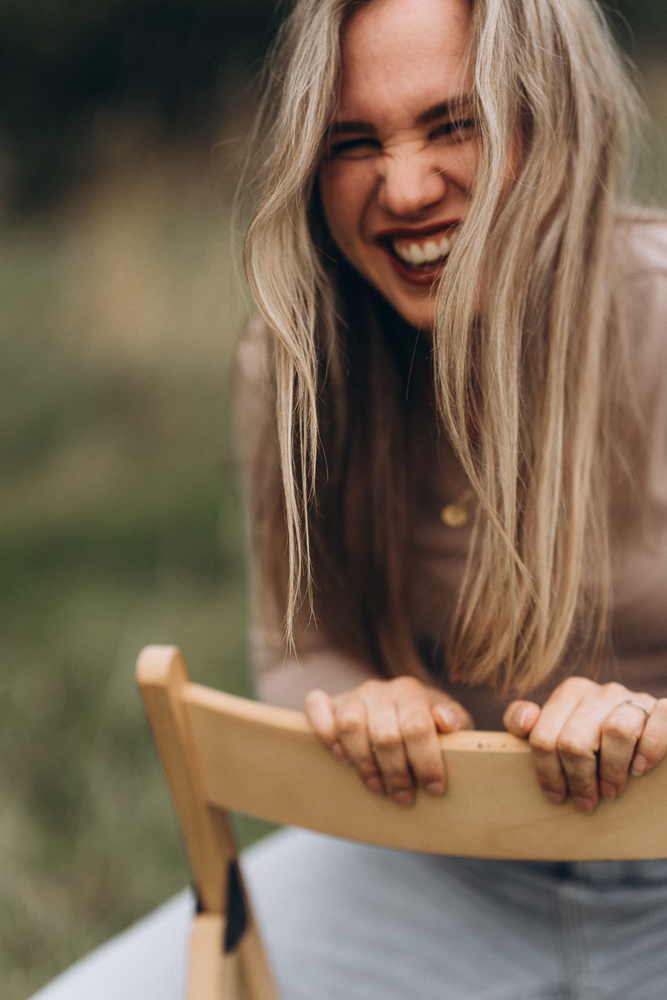 Portraitshooting Frau lachend auf Stuhl