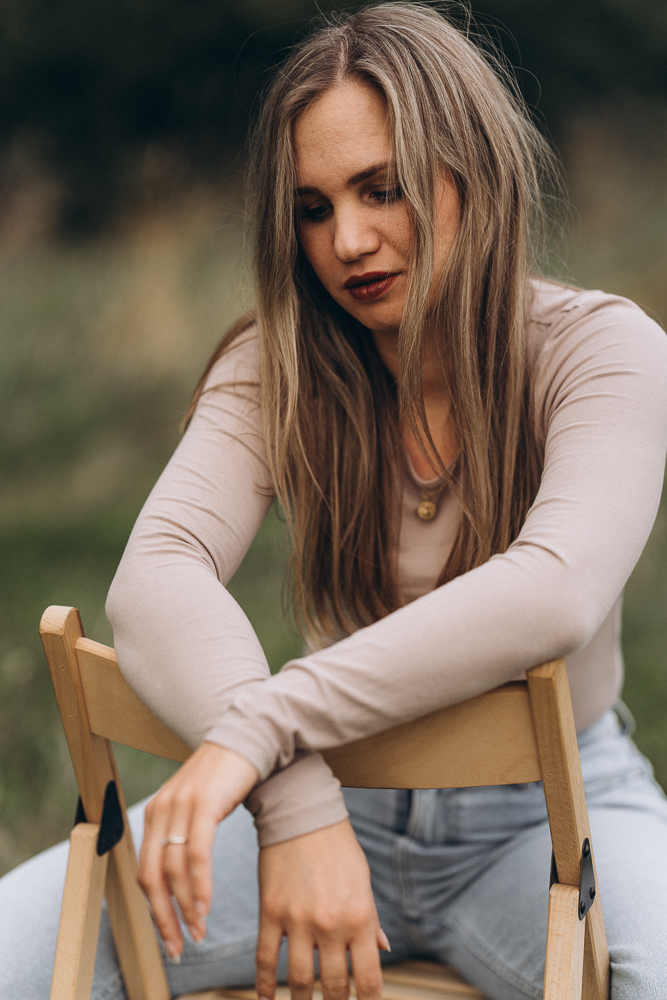 Portraitshooting Frau auf Stuhl in Gedanken