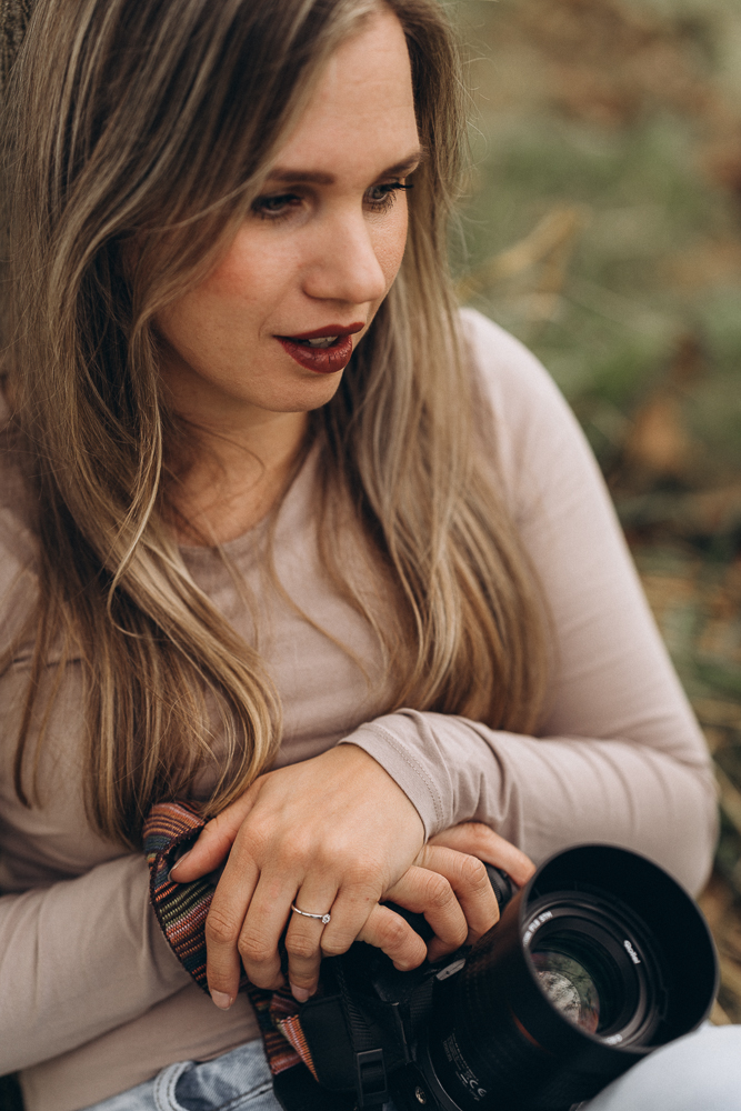 Portraitshooting Frau sitzend mit Kamera verträumt