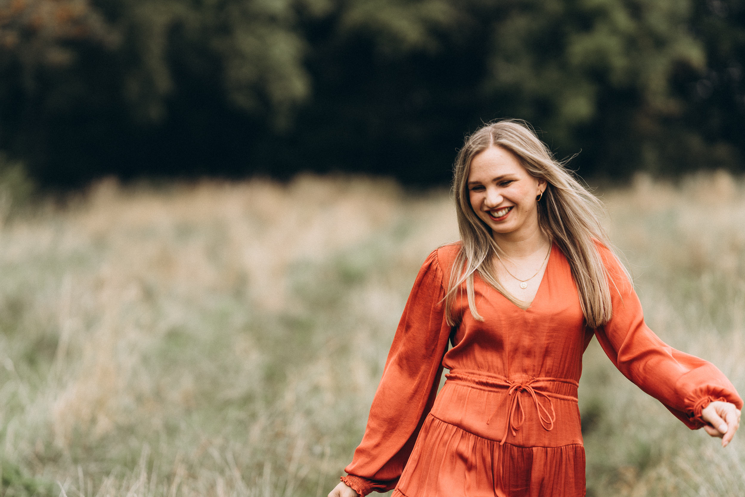 Portraitshooting Frau in rotem Kleid läuft fröhlich beschwingt