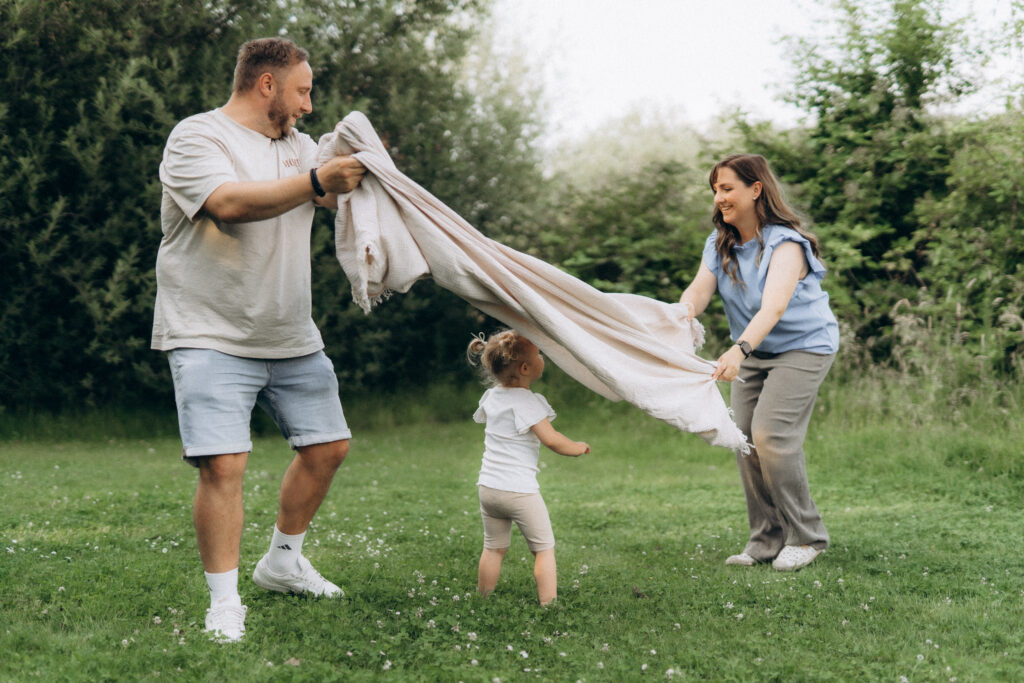 Familienshooting lachend mit Decke Spaß